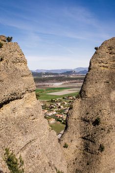 two large rocks with houses on them in the middle of a mountain range near town