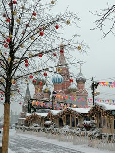 the christmas decorations are on display in front of the building and trees covered with snow