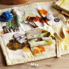 a table topped with lots of crafting supplies on top of a wooden table next to scissors