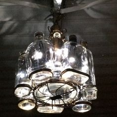 a chandelier hanging from the ceiling in a dark room with lights on it