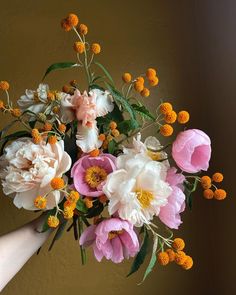 a person holding a bouquet of flowers in their hand