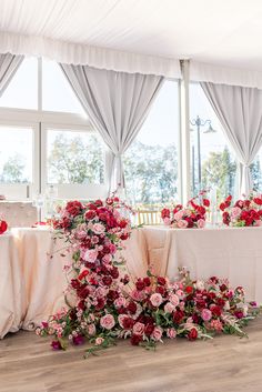 the table is set up with pink and red flowers