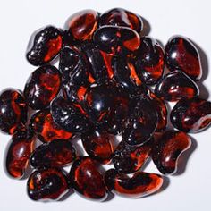 a pile of red and black marbles on a white surface