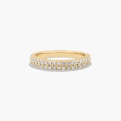 a yellow gold band with rows of diamonds on the side, in front of a white background