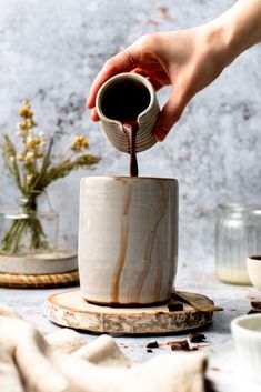 a person pouring coffee into a cup