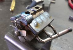 a close up of a metal object on a table with other tools in the background