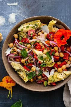 a bowl filled with vegetables and chickpeas on top of a blue table cloth