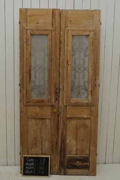 an old pair of wooden doors sitting next to a chalkboard with writing on it