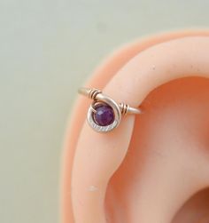 an ear with a purple stone in it