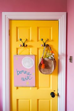 a yellow door with a pink and yellow wall