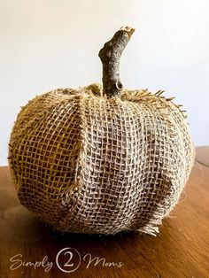 a burlap pumpkin sitting on top of a wooden table