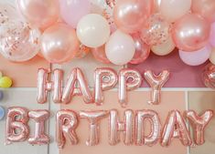 balloons and confetti are arranged around the words happy birthday on a pink background