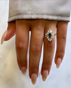 a woman's hand with a ring on it and a flower in the middle