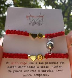 two bracelets that have hearts on them with words written in spanish and latin writing