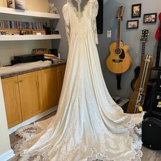 a wedding dress is on display in a room with guitars and other musical instruments behind it