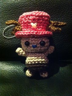 a small crocheted stuffed animal wearing a red hat