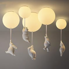 some white lights hanging from the ceiling with bears and balloons attached to each light fixture