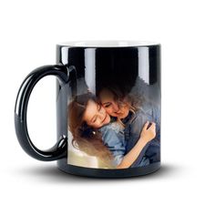 a black coffee mug with two women hugging each other