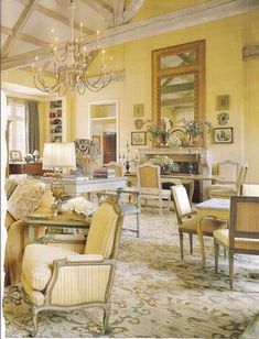 a living room filled with lots of furniture and a chandelier hanging from the ceiling