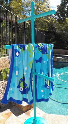 two towels hanging on a rack next to a swimming pool