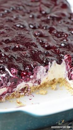 a close up of a dessert on a plate with blueberries and cream toppings