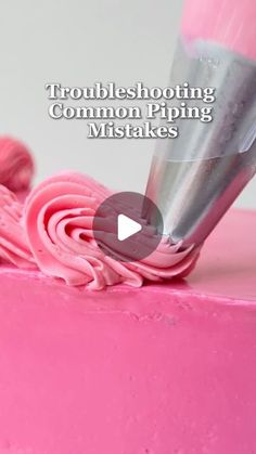 a pink cake with frosting being applied to it