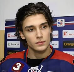 a young man in a blue and red jersey holding a microphone with the number 3 on it