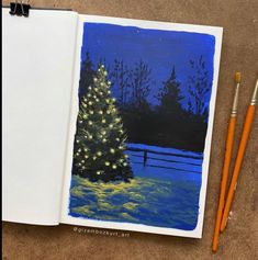 an open notebook with a christmas tree and two pencils