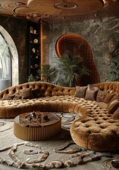 a living room filled with lots of brown couches and pillows on top of a rug