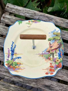 a plate with a wooden handle sitting on top of a bench