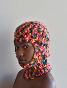 a woman wearing a multicolored crocheted hat and neckwarf,