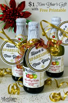 three bottles of sparkling new year's eve wine with gold ribbon and red poinsetti