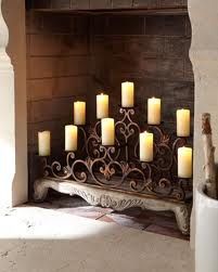 a bunch of lit candles sitting on top of a bench in front of a fireplace