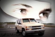 a woman's eyes are reflected in the reflection of a car on a road