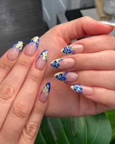 Almond-shaped nails with blue and yellow floral designs on a nude base, showcasing trendy, tropical-inspired nail art. Beach Acrylic Nail Designs, Nail Art Designs Tropical, Teal Floral Nails, Almond Tropical Nails, Blue Flower Summer Nails, Blue Nails Inspiration Summer, Cute Bday Nails Short, Hawaii Nails Almond Shape, Summer Nails Beach Vibes