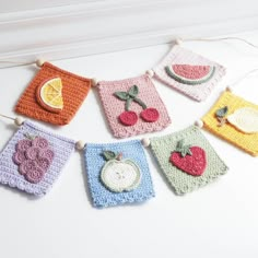 crocheted fruits and vegetables are hanging on the clothes line with strings attached to them