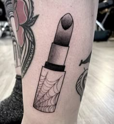 a black and white photo of a lipstick on the leg