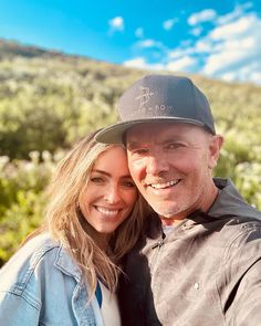 a man and woman taking a selfie in front of the camera on a sunny day