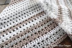 a crocheted blanket sitting on top of a wooden floor