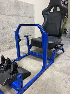 a black and blue gaming chair sitting on top of a metal frame in a room