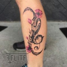 a tattoo with music notes and flowers on the leg, it looks like someone has done something