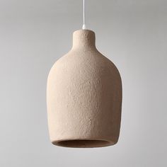 a white ceramic light fixture hanging from a ceiling