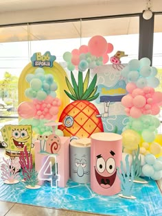 a table topped with balloons and decorations for a spongebob themed birthday party or baby shower