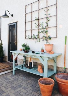 potted plants are sitting on a table in front of a house