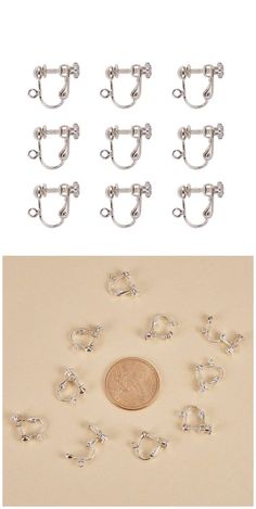 a penny sitting next to several pairs of silver earring hooks on top of a table