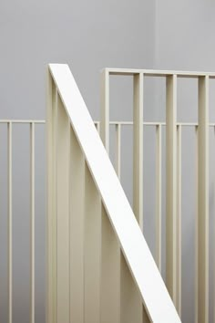 a cat sitting on top of a wooden stair case next to a white rail and door