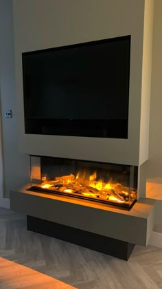 a television mounted on top of a wall next to a fire place