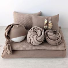 a bed with two pillows and some blankets on top of it next to a bowl