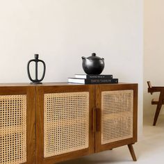 a sideboard with some books and a teapot on top