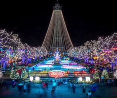 people are walking around in front of the christmas lights at disneyland's holiday village